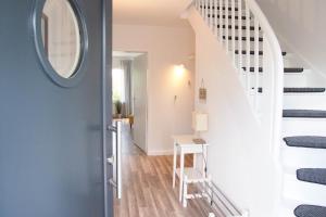 a hallway with a white staircase with a round mirror at Bootshaus in Timmendorfer Strand