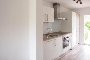 a kitchen with white cabinets and a sink at Bootshaus in Timmendorfer Strand