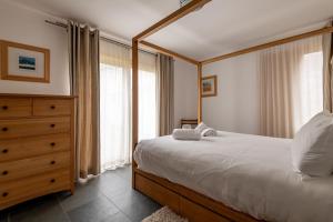 a bedroom with a bed and a dresser and windows at Juniper Cottage - Elie in Elie