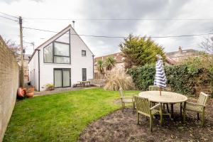 a house with a table and chairs in the yard at Juniper Cottage - Elie in Elie
