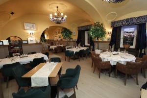 a restaurant with tables and chairs and a chandelier at Garni Hotel Leopold I in Novi Sad