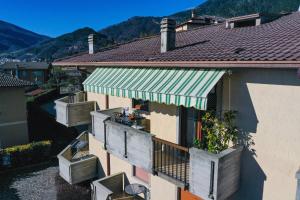 a building with a balcony with a green awning at La Portella - Gardagate in Tignale