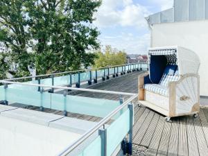 a wicker chair on the balcony of a building at Loft in Timmendorfer Strand