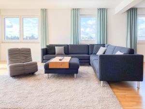 a living room with a blue couch and a chair at Loft in Timmendorfer Strand