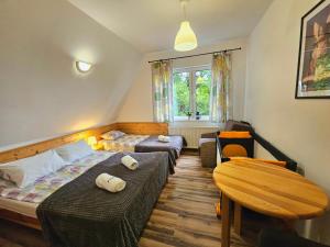 a bedroom with two beds and a table and a chair at Zającówka in Polanica-Zdrój