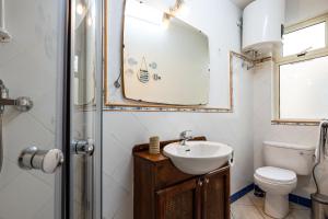 a bathroom with a sink and a toilet and a mirror at GhadiraBay seafront with sea views by Homely in Mellieħa +32 photos