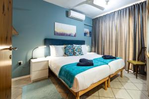 a bedroom with a large bed with blue walls at GhadiraBay seafront with sea views by Homely in Mellieħa