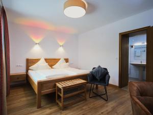a bedroom with a bed and a chair at Ferienweingut-Liebfried in Nehren