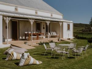 a house with chairs and a table and a table and chairs at Vleidam Guest Farm in Koringberg