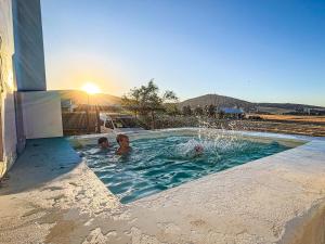 two children playing in a swimming pool with a fountain at Vleidam Guest Farm in Koringberg