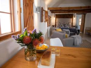 a vase with flowers and a bowl of fruit on a table at Vleidam Guest Farm in Koringberg