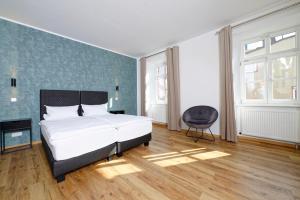 a bedroom with a bed and a chair in it at Boardinghouse Rosenheim in Rosenheim