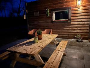 a wooden picnic table sitting on a patio at Vinkenland in Koningslust
