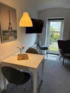 a room with a table with chairs and a view of the eiffel tower at Klitgaards Holiday Apartment in Mejeriby