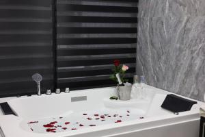 a white bathtub with a flower on top of it at Panorama Lisi Grand Hotel in Tbilisi City