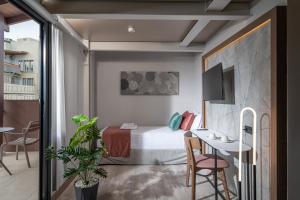 a hotel room with a bed and a table and a desk at Infinity City Boutique Hotel in Heraklio