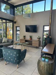 a living room with a couch and a tv at The Jade, Somerset West in Strand
