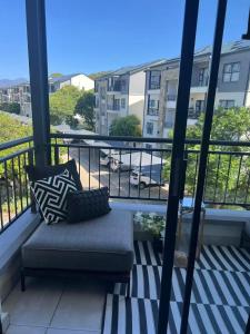 a couch on a balcony with a view of a street at The Jade, Somerset West in Strand