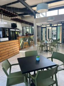 a restaurant with tables and chairs and a kitchen at The Jade, Somerset West in Strand