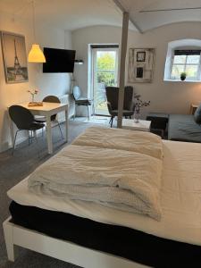 a bedroom with a bed and a living room at Klitgaards Holiday Apartment in Mejeriby