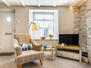 a living room with a chair and a television at 1 Bed in Wadebridge oc-87740 in Wadebridge