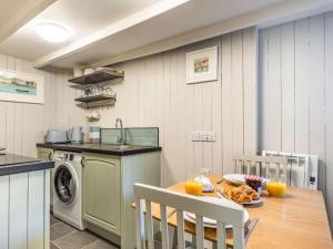 a kitchen with a table and a kitchen with a washing machine at 1 Bed in Wadebridge oc-87740 in Wadebridge +13 photos