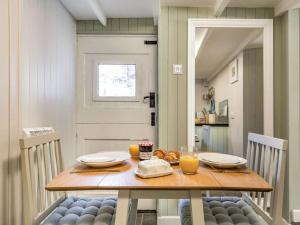 a dining room table with two chairs and orange juice at 1 Bed in Wadebridge oc-87740 in Wadebridge