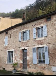 an old brick building with windows and a door at chambre O'nids in Cahors