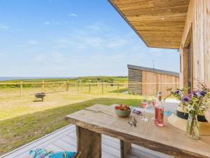 a wooden table on a deck with a view of a field at 1 Bed in Bude oc-88498 in Morwenstow
