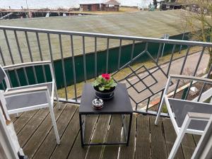 a table with a plant on a balcony with two chairs at Ferienwohnung Müritz-Blick in Waren