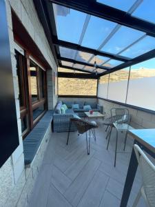 a rooftop patio with a couch and tables and chairs at Hotel Restaurante Valdevenados in Anguiano