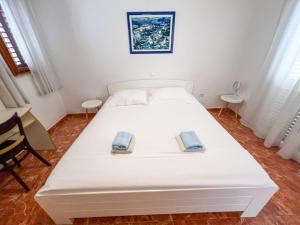 a white bed in a room with two towels on it at Robinson Apollon in Gdinj