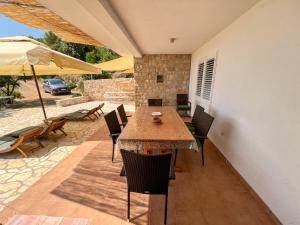 a patio with a table and chairs and an umbrella at Robinson Apollon in Gdinj +18 photos