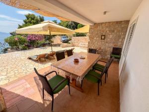 a patio with a table and chairs and an umbrella at Robinson Apollon in Gdinj