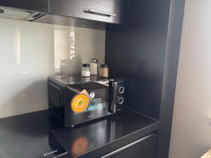a microwave on a counter with an orange on it at Ferienwohnung Müritz-Blick in Waren