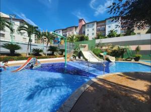 a swimming pool with a slide in front of a building at Flat veredas 300 metros HOT PARK com ar na sala in Rio Quente