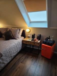 a bedroom with a bed and a table with a window at Veenemaat B&B in Winterswijk