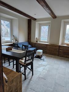 a living room with a table and chairs and windows at Alleghe Lodge in Masarè