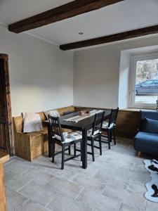 a dining room with a table and chairs and a couch at Alleghe Lodge in Masarè