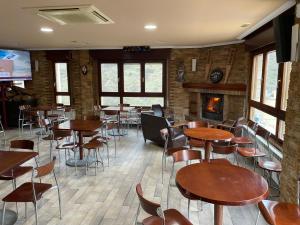 a restaurant with tables and chairs and a fireplace at Hotel Restaurante Valdevenados in Anguiano