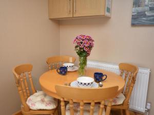 a dining room table with a vase of flowers on it at 1 Bed in Wadebridge oc-42756 in Wadebridge