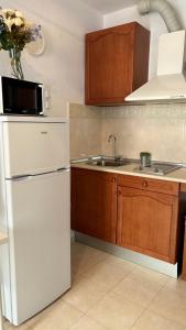 a kitchen with a white refrigerator and a sink at Apartamento Amy 4 in Huelva +29 photos
