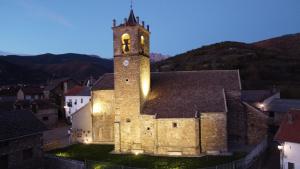 an old building with a clock tower at night at Casa lo Sastre - Jasa in Jasa