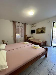 a bedroom with a large bed and a couch at Rooms Villa Desa in Budva