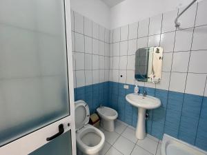a small bathroom with a toilet and a sink at Beach Home Retreat in Durrës +14 photos