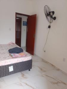 a room with a bed and a fan on the wall at Terramar condominium! Coral beach! in Tamoios +43 photos