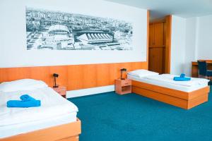 two beds in a room with a picture on the wall at Hotel Ledňáček in Ostrava
