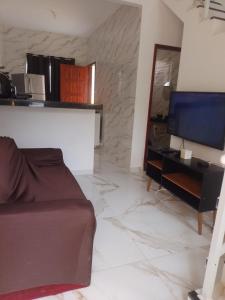 a living room with a couch and a television at Terramar condominium! Coral beach! in Tamoios