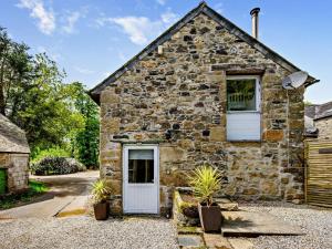 an old stone house with a white door and two windows at 2 Bed in Bodmin oc-90216 in Bodmin