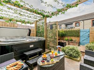a patio with a hot tub and a table with food at 3 Bed in St. Austell oc-90218 in Charlestown